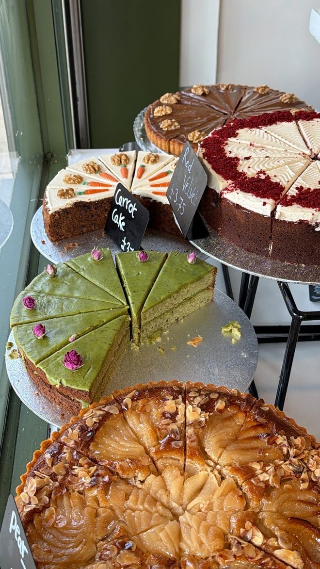 A stack of whole cakes on stands by the café window