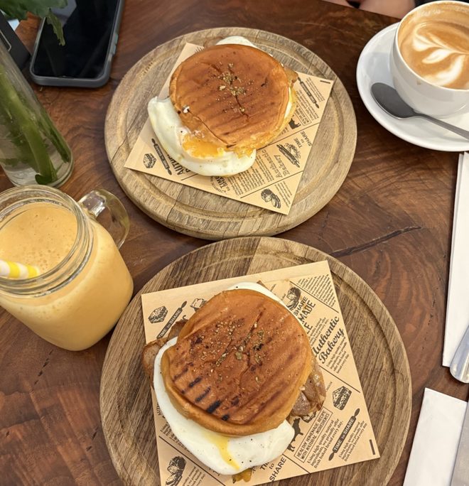 Brunch plates of poached eggs on toasted muffins with coffee and juice