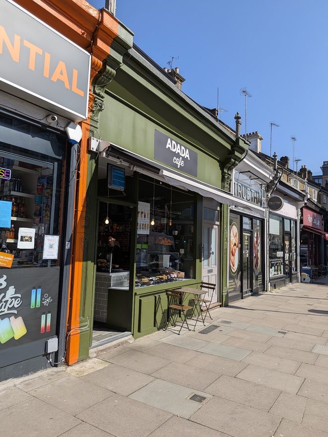 The green shopfront and pavement seating of Adada Cafe