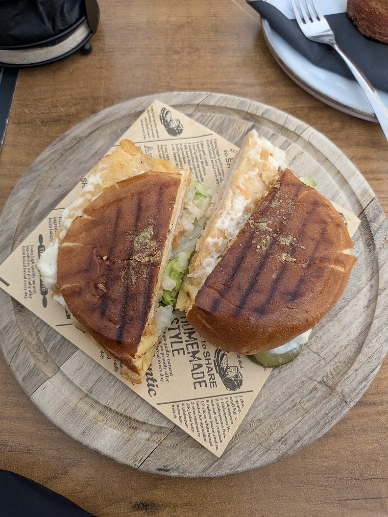 A grilled panini cut in half on a wooden board